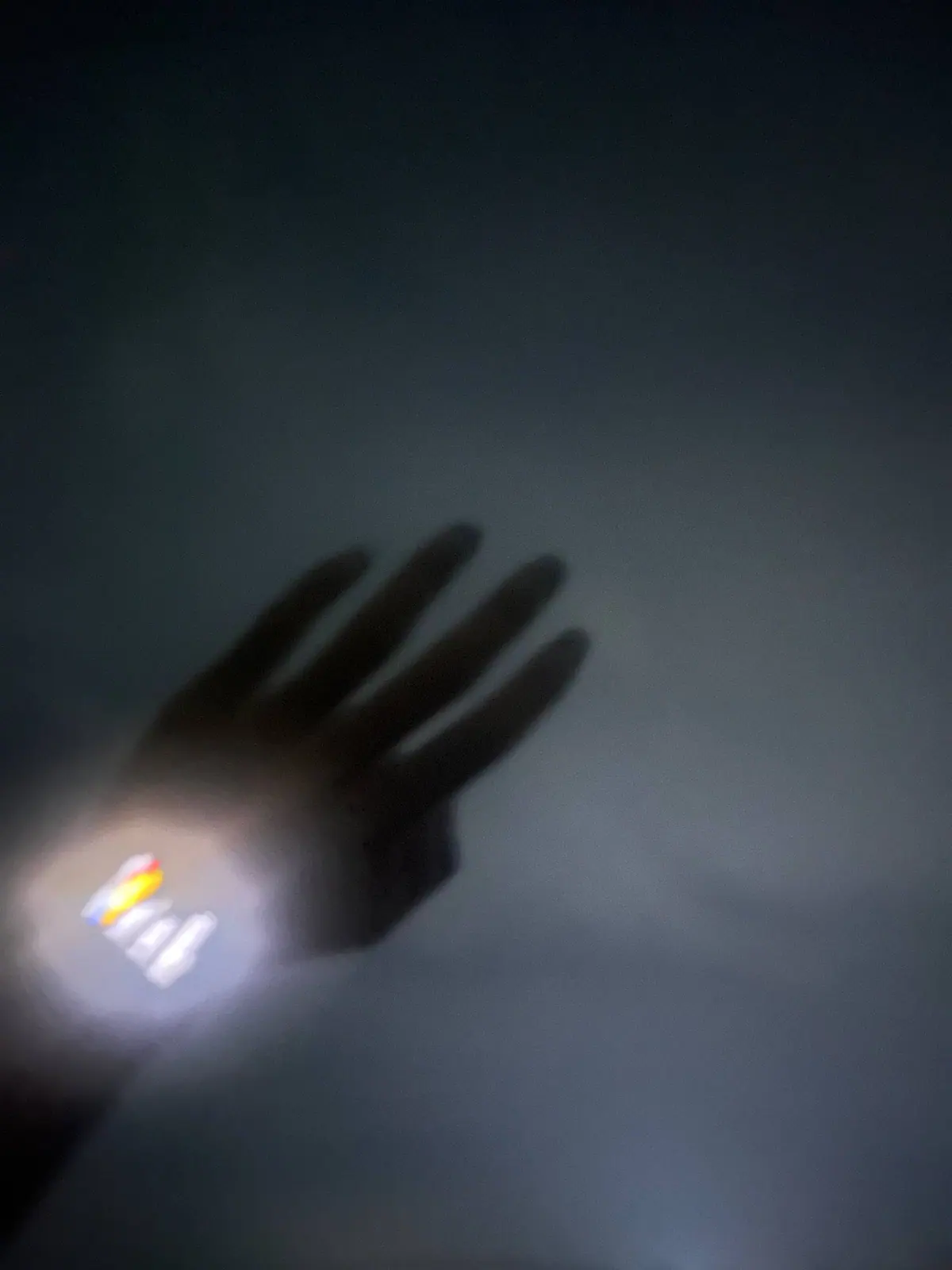 A blurred hand and wristwatch moving across a dark gray background.